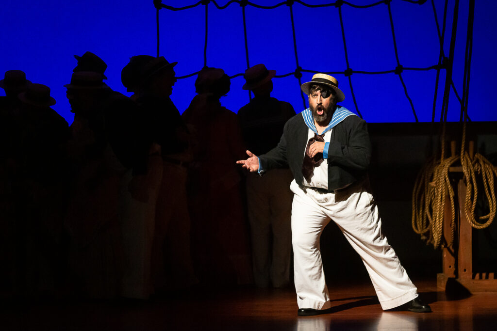 Dick Deadeye (Joe Carl White) tells the audience in a musical aside his plans to thwart the blossoming love of Ralph and Josephine.